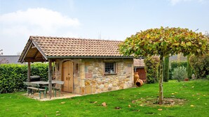 Ein Steinhaus mit Ziegeldach, einer Holztür und einem kleinen Fenster.