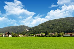 Ländliche Landschaft mit Kirche, Häusern und einem grünen Feld.