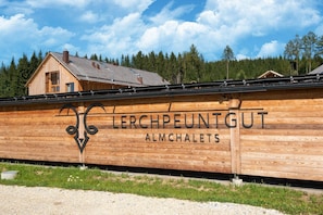 A wooden building with the text "Lerchpeuntgut Almchalet" on its side. - Chalet in Wölting with natural swimming pond (Wölting)