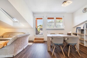 Moderni parvi-tyyppinen asunto, jossa on parvisänky, ruokailutila ja näkymä ulos.