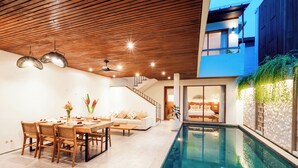 A modern interior with a dining area, a pool, and a staircase leading to an upper level. - Villa Casanaya Pererenan Canggu (Canggu)