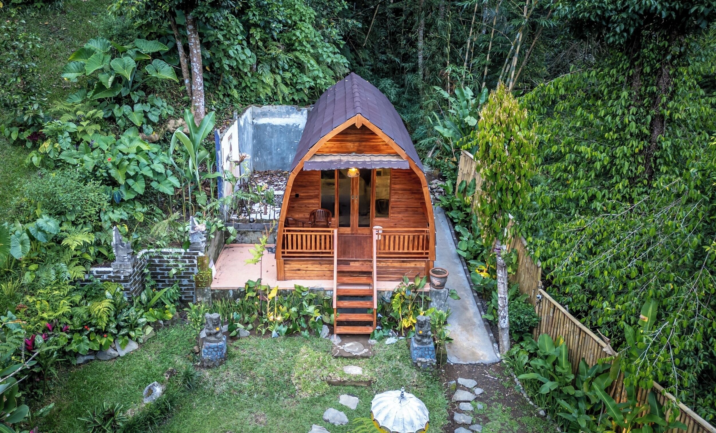 Una cabaña de madera pequeña con un porche y una escalera que lleva a la entrada.