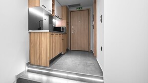 Una cocina moderna con armarios de madera, un microondas y un lavaplatos de acero inoxidable.