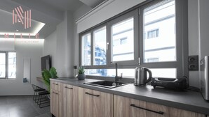 Una cocina moderna con un ventanal grande, un fregadero y una tetera.