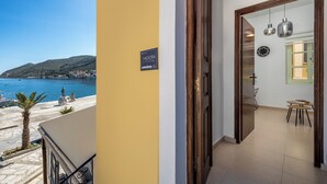 A hotel room with a view of the sea and a sign indicating 'Aegean Studio'.