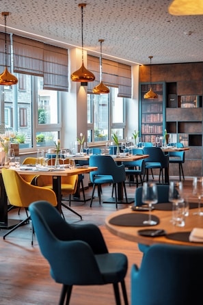 A modern dining area with tables, chairs, and hanging pendant lights. - Wetzlarer Hof Hotel & Restaurant (Wetzlar)
