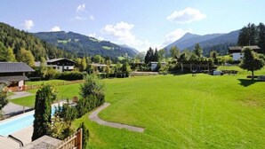 Un quartier résidentiel avec des maisons, une piscine et une grande pelouse verdoyante.