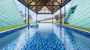 A swimming pool with a tiled floor and a covered area with a roof. - Sacheon Ara Private Pool Villa (Sacheon)