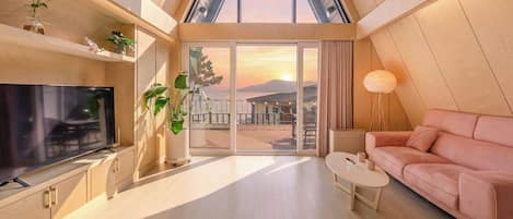 Una sala de estar moderna con televisor, sofá, mesa de centro y plantas en macetas.