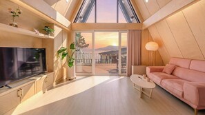 Una sala de estar moderna con televisor, sofá, mesa de centro y plantas en macetas.
