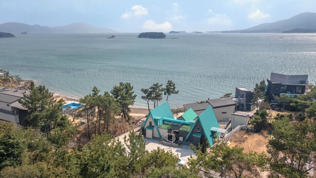 A coastal property with a pool, a boat dock, and a view of the sea. - Sacheon Ara Private Pool Villa (Sacheon)