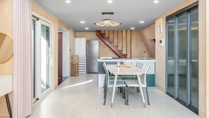 A modern kitchen with a central island, a built-in oven, and a stainless steel refrigerator. - Sacheon Ara Private Pool Villa (Sacheon)