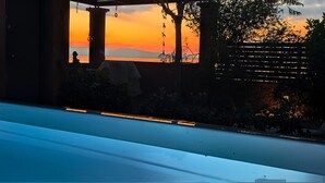 A pool area with a sunset view, a covered seating area, and a wooden fence. - La Casa del Sol Sea View Sunset Jacuzzi (Aegina)