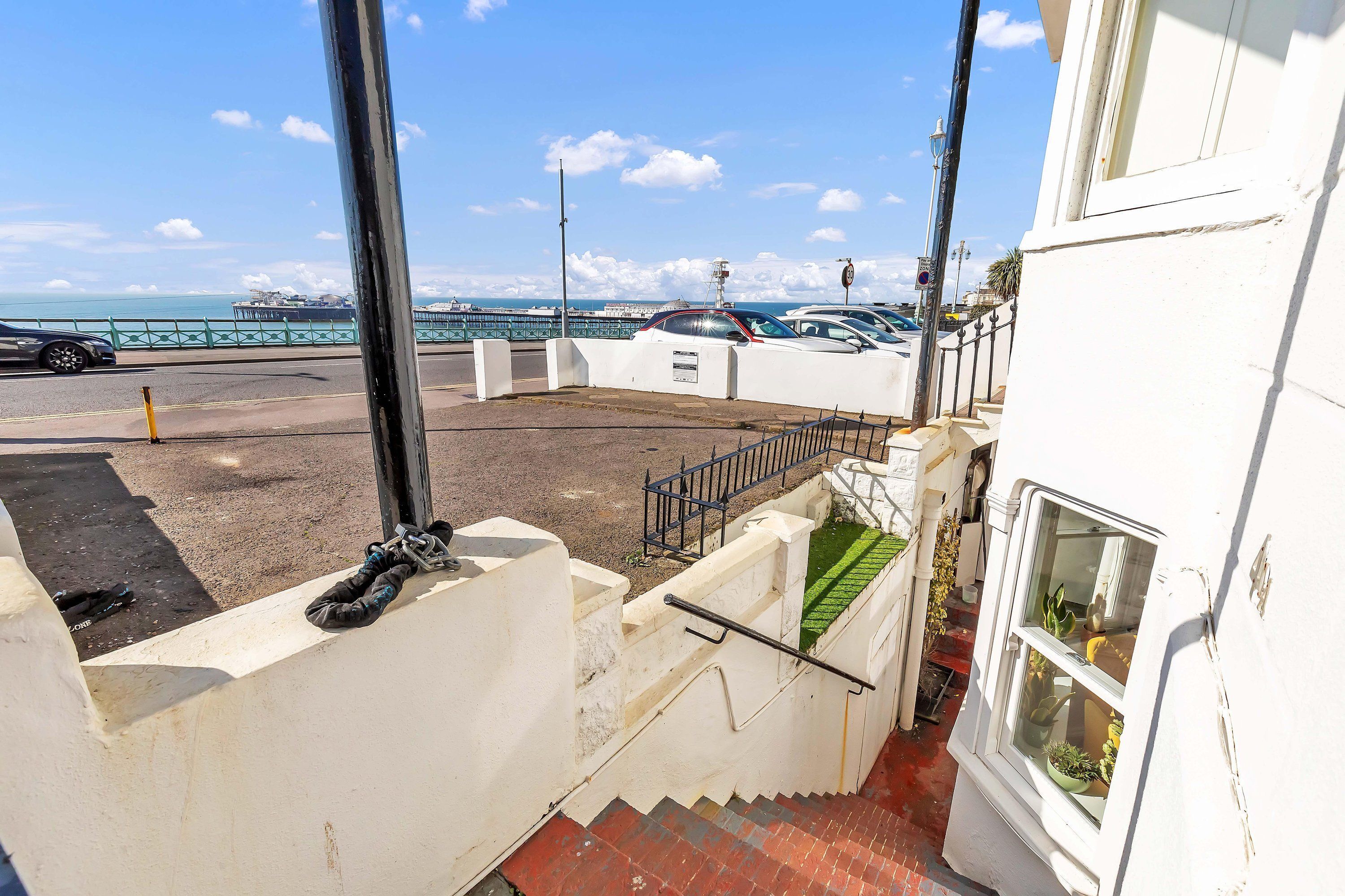 Un escalier menant à un bâtiment blanc, d’où l’on a une vue sur la mer.