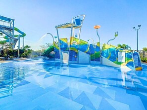 A water park with a large pool, slides, and a wave machine.