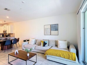 Una sala moderna con sofá, mesa de centro y comedor.