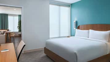 A hotel room with a bed, a desk, and a chair.