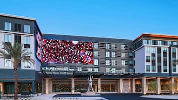 Ein Hotel mit einer großen digitalen Anzeige an der Fassade, einem modernen architektonischen Design und einem gepflegten Außenbereich.
