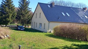 Une maison avec un toit en pente, un garage et une pelouse bien entretenue.