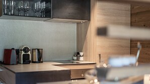 A modern kitchen with a built-in stove, coffee maker, and salt and pepper shakers.