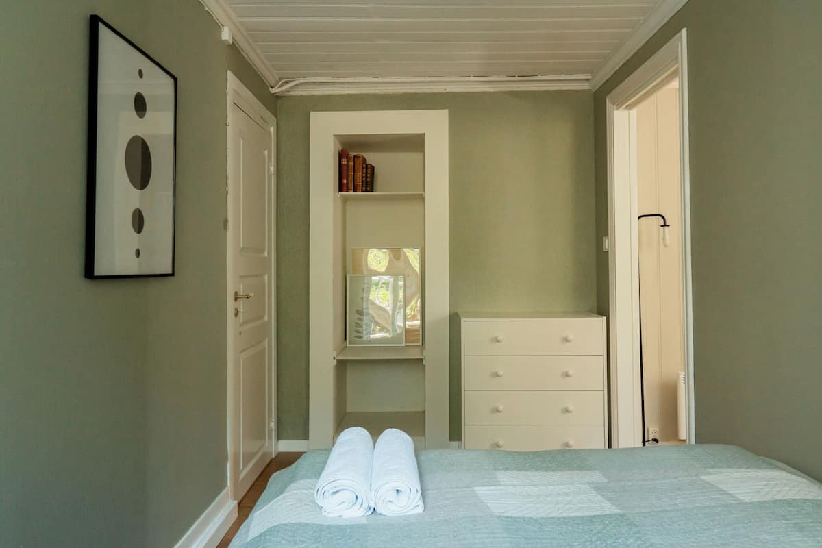 Una camera da letto con un letto, un armadio e un quadro appeso al muro.