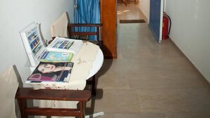Ein Flur mit Essbereich, einer Lampe, einem Tisch mit Zeitschriften und einer Tür zum Balkon.