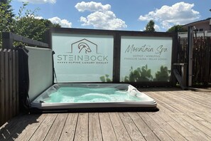 Un bain à remous installé à l’extérieur, sur une terrasse en bois.