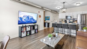A modern kitchen with white cabinets, stainless steel appliances, and a marble countertop. - Steps Away From Mass Ave in Heart of Indy with Balcony (Indianapolis)