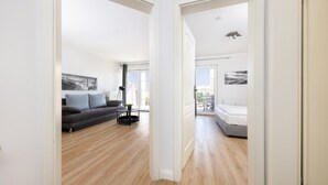 Een modern appartement met een woonruimte, een balkon en een slaapkamer.