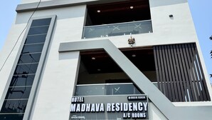 A modern building with a sign for 'Madhava Residency A/C Rooms' and a contact number. - HOTEL MADHAVA RESIDENCY (Kakinada)
