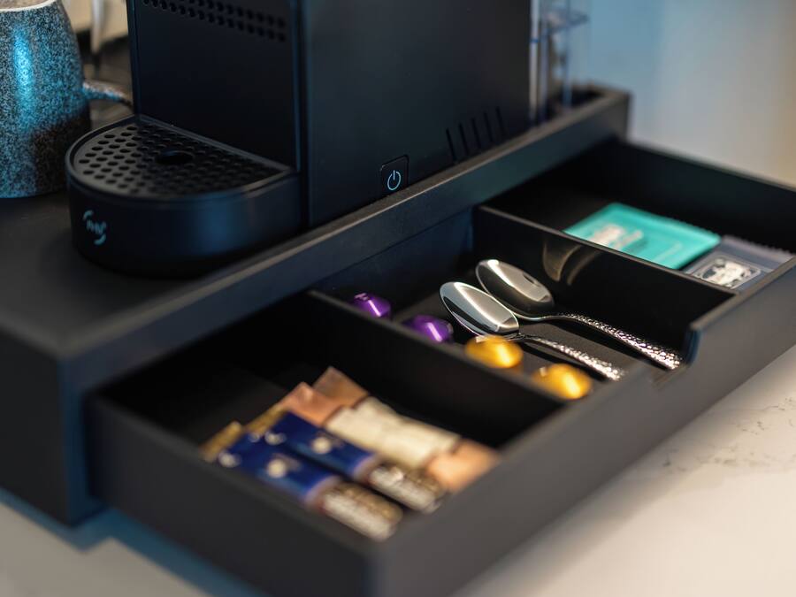 Eine Schublade mit verschiedenen Gegenständen, darunter Batterien, eine Maus und ein USB-Stick.