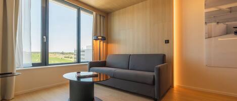 Una sala de estar moderna con un sofá, una mesa de centro y un ventanal grande.