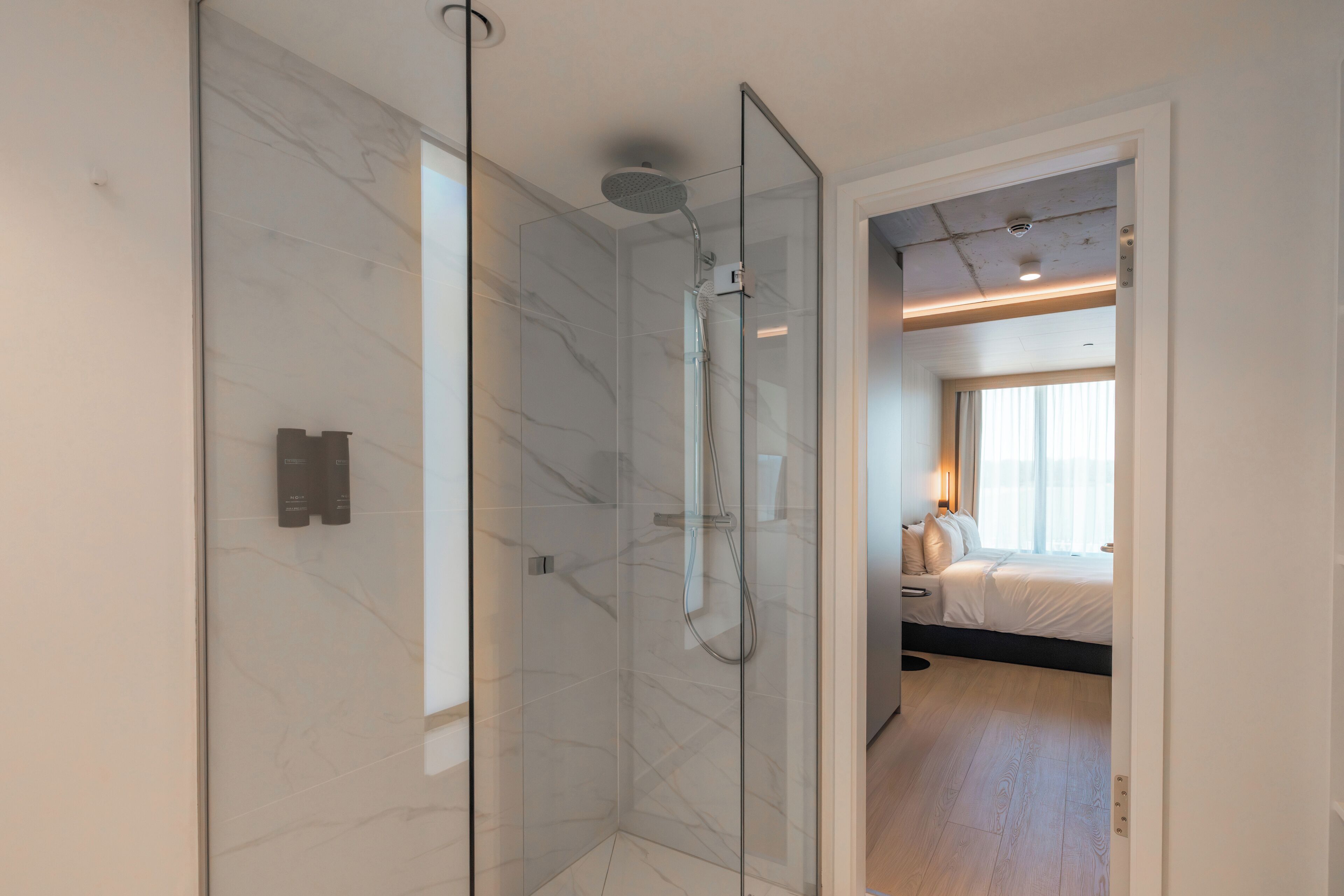 A modern bathroom with a glass-enclosed shower and a visible toilet.
