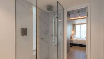 A modern bathroom with a glass-enclosed shower and a visible toilet.