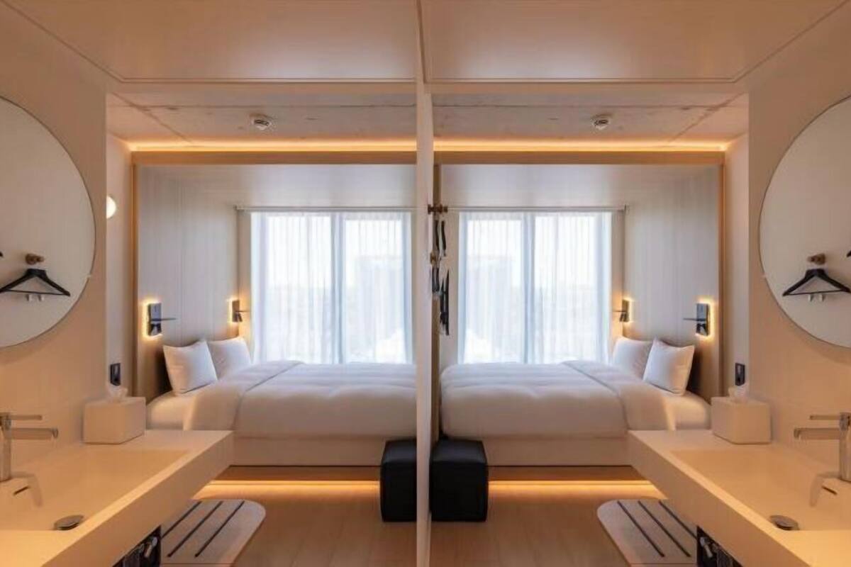 Habitación con espejo, una cama, mesitas de noche y un ventanal grande.