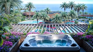Ein Whirlpool mit Blick auf einen Pool, umgeben von Palmen und Blumen.
