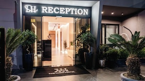 A hotel reception with a glass door, a sign above the door, and a doormat with the hotel's name. - The Lord's Garden (Ksamil)