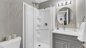 A modern bathroom with a walk-in shower, a vanity with a mirror, and a toilet. - Your Comfort Spot in Niagara |Mins away from Falls (Niagara Falls)