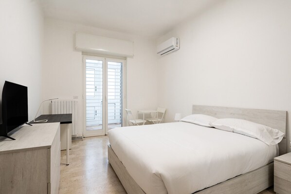 A bedroom with a bed, a desk, a chair, and an air conditioning unit. - Febe Apartment by Wonderful Italy (Bari)