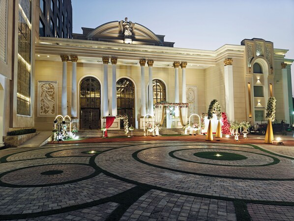 A grand entrance with classical columns, a red carpet, and floral decorations.