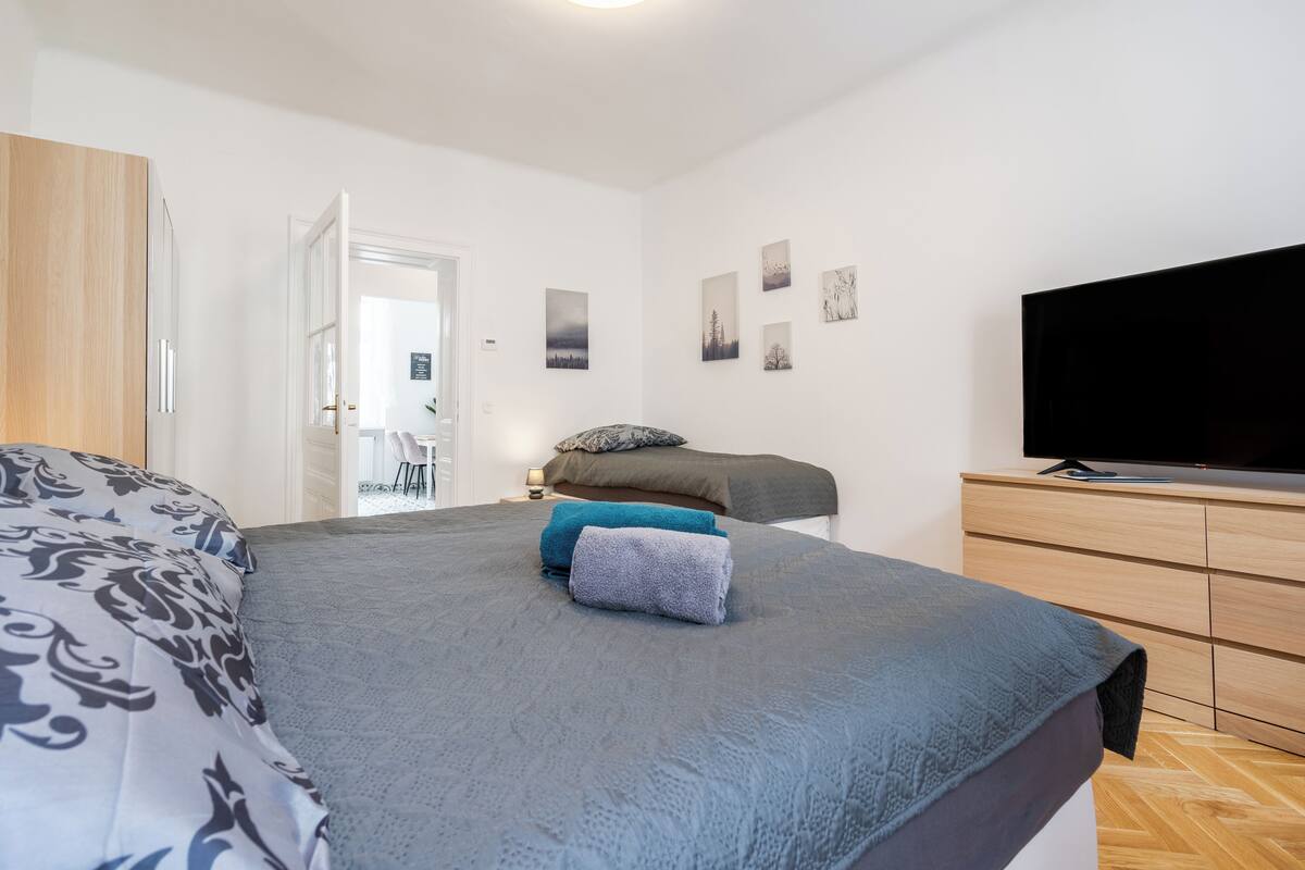 Ein Schlafzimmer mit einem Bett, einem Fernseher und einem Schminktisch.
