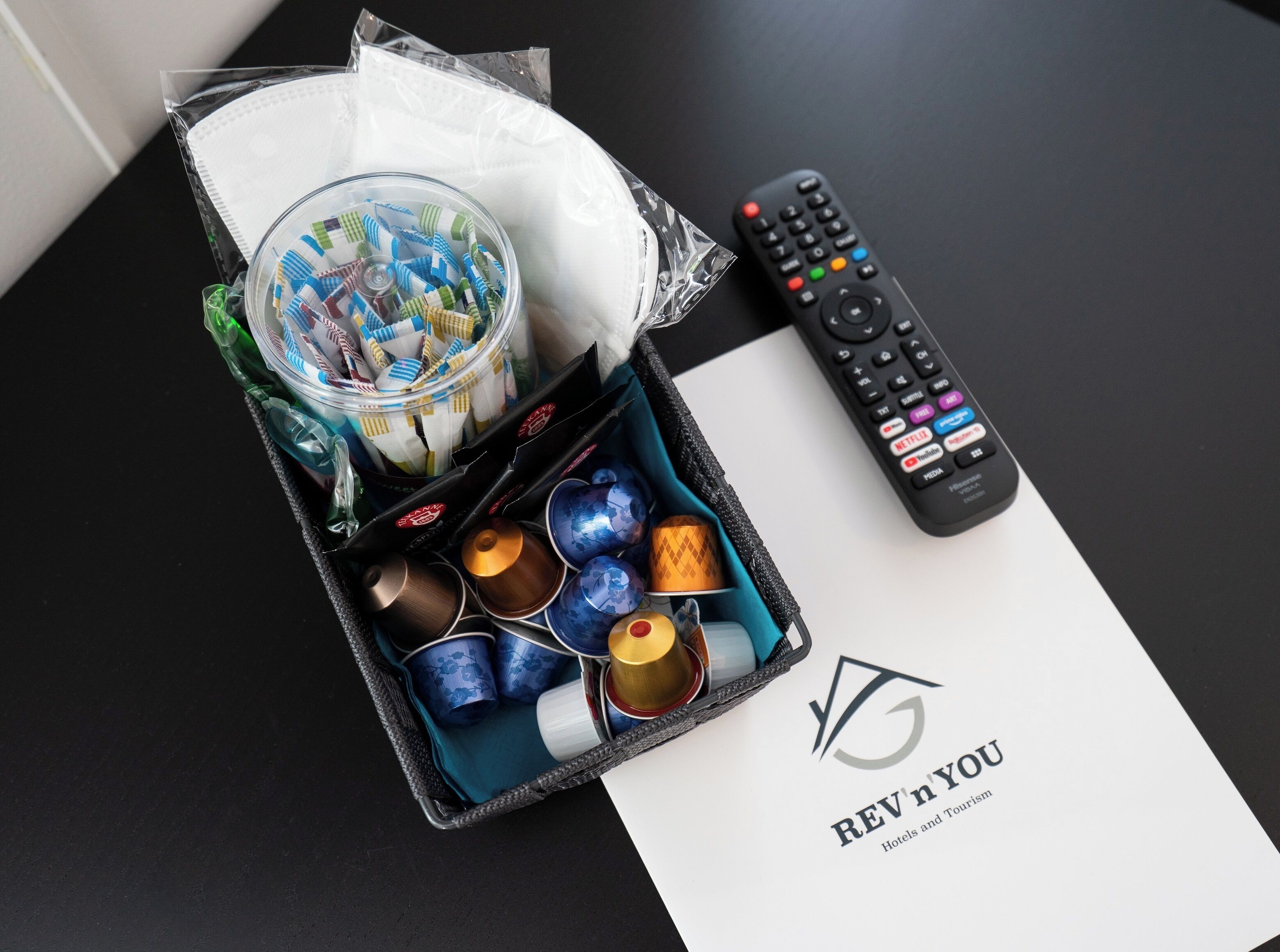 A travel bag with a remote control, a tissue box, and a branded item.