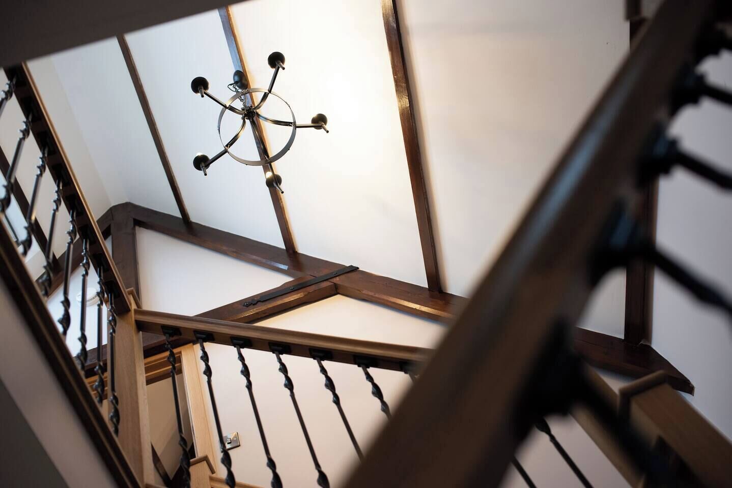 A staircase with wooden railings and a chandelier.
