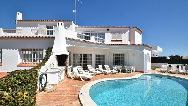 Un espace aménagé au bord de la piscine, avec des chaises longues et un barbecue.