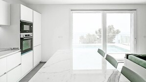 A modern kitchen with white cabinetry and a marble countertop. - Orizzonti Blu Pool Villa by Wonderful Italy (Cervo)