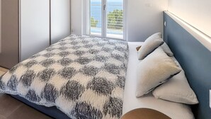 A bedroom with a bed, a wardrobe, and a window with a view. - Orizzonti Blu Pool Villa by Wonderful Italy (Cervo)