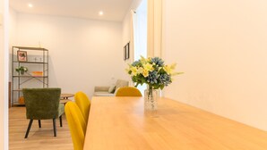 A dining area with a wooden table, yellow chairs, and a vase of flowers.