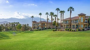 A multi-story hotel with a flat roof, surrounded by palm trees and a well-maintained lawn. - Marriott's Desert Springs Villas II | Studio (Palm Desert)