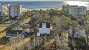 Ett bostadsområde vid kusten med flera hyreshus, en parkeringsplats och en strand i bakgrunden.
