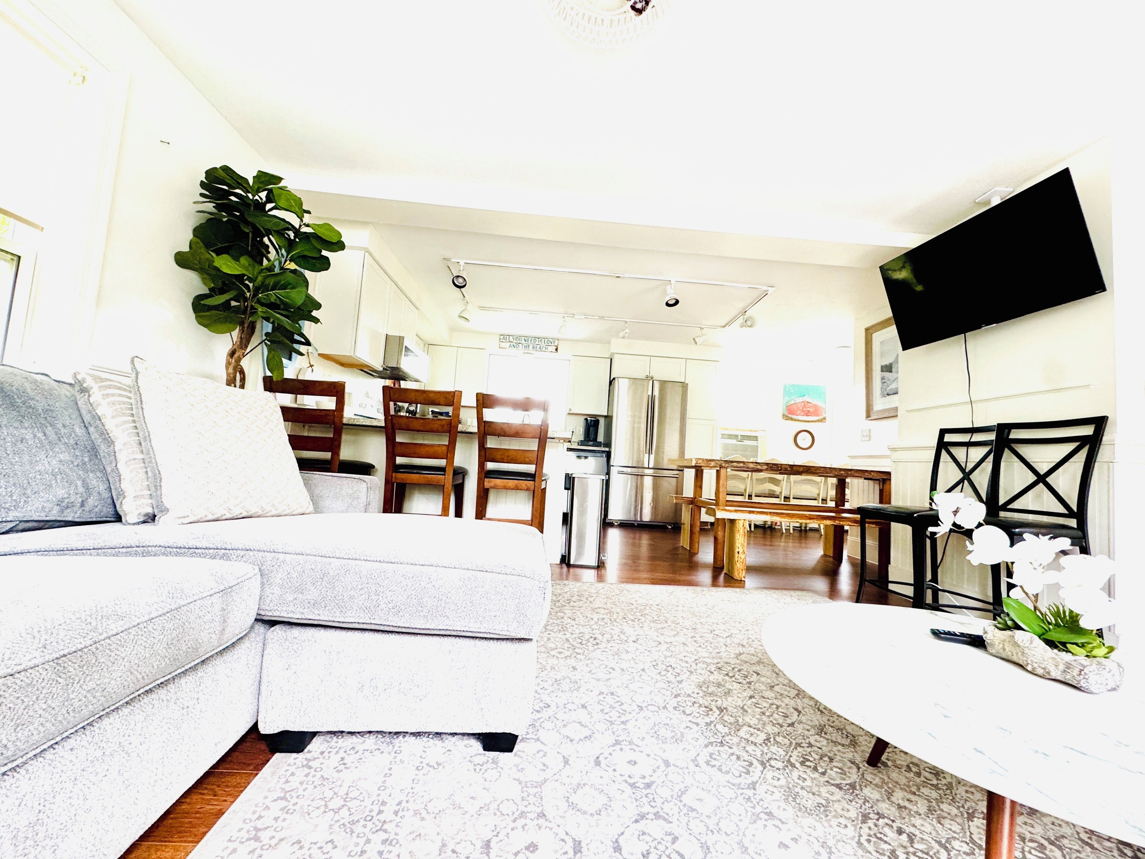 A living room with a sofa, a coffee table, and a dining area with chairs and a table.